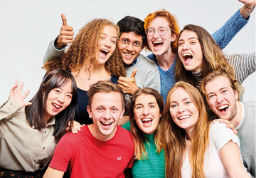 Group of students huddled together smiling at the camera