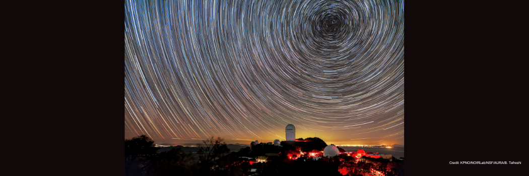 DESI maps distant objects to study dark energy. The instrument is installed on the Mayall Telescope, shown here beneath star trails.