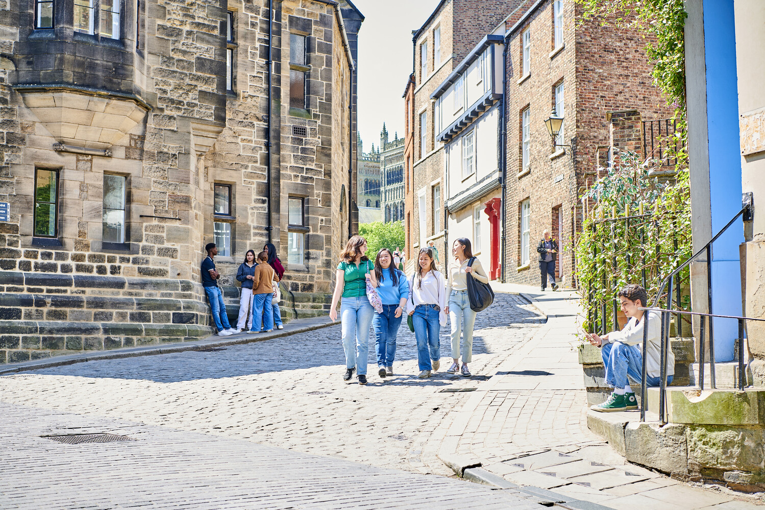 A group of students walking down a cobbled street in Durham