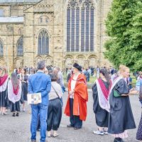 A group of guests, students and staff stood on Palace Green