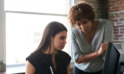 A woman and younger adult looking at a laptop