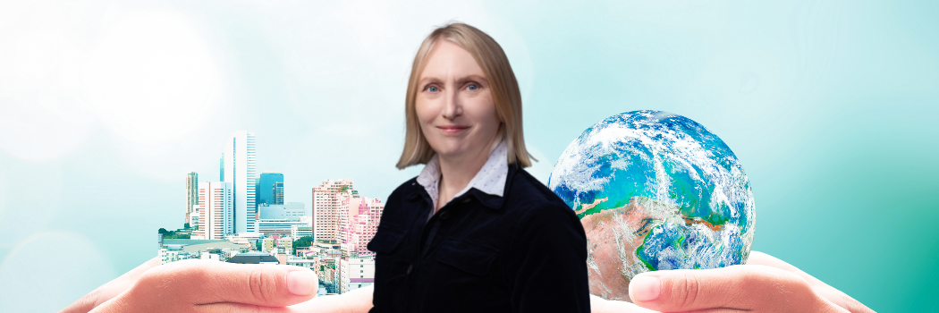 Carol Adams with two human hands holding earth global and big city on blurred nature backdrop