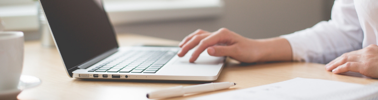 A hand typing on a laptop