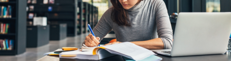 A student studying at a desk with books