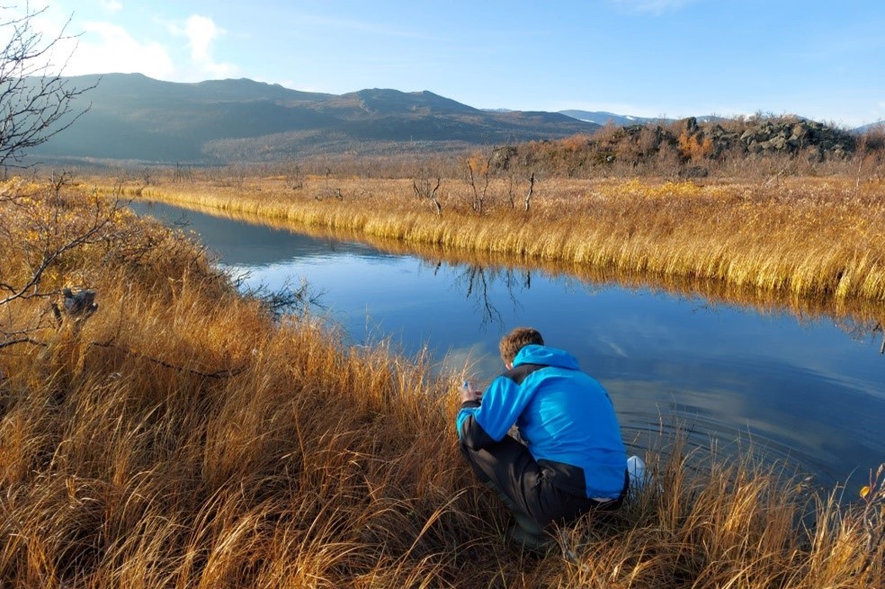 Polar Scientist at work by a river