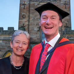 Alumnus Neil Hunt and partner, Julie Raymond. Neil in hon grad robes.