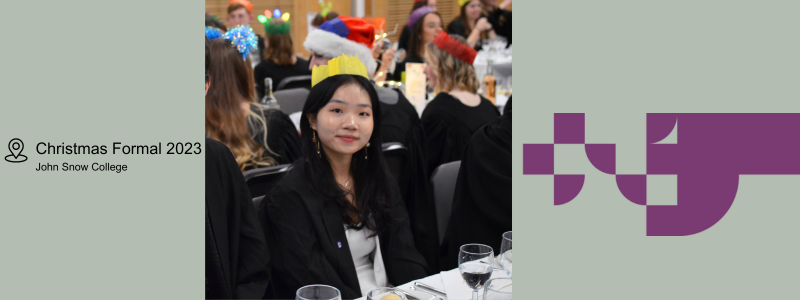 Young woman with long dark hair sat in a gown at a formal dinner