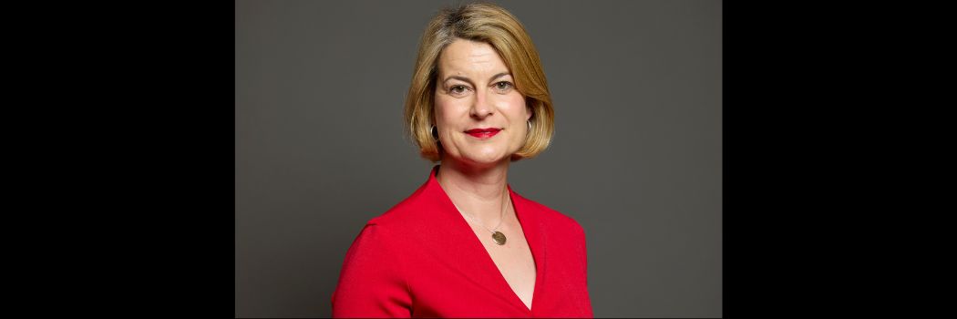 A woman, visible from shoulders upwards, looking directly at camera