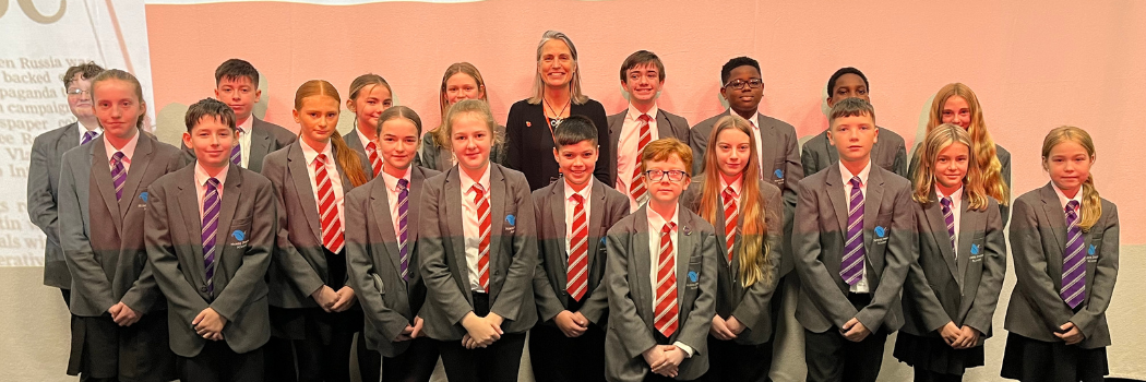 Fiona Hill smiling stood with pupils at North Durham Academy