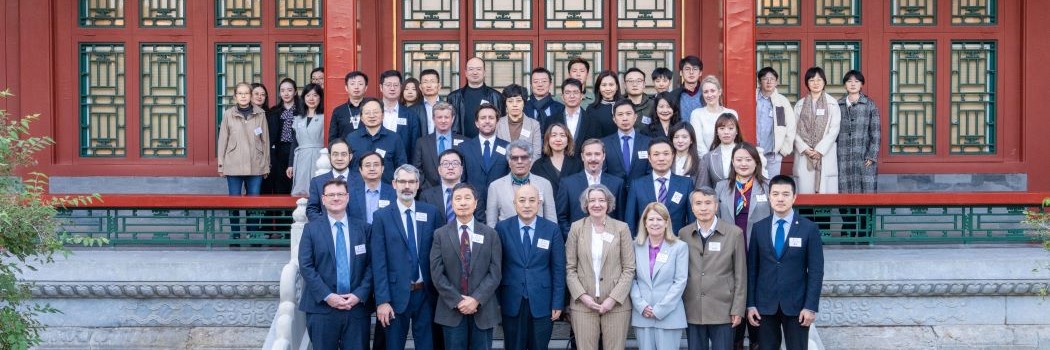 a group of people standing for a photograph with the Palace Museum in the background