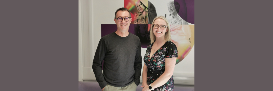 Dr Toni Williams (right) and Professor Martin Roderick (left) smiling in front of a Durham University banner