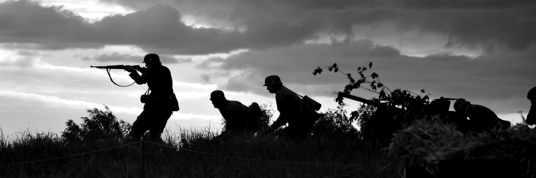 Silhouette of crouching soldiers holding rifles