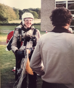 Student in parachute gear, having landed on the lawn at Van Mildert College