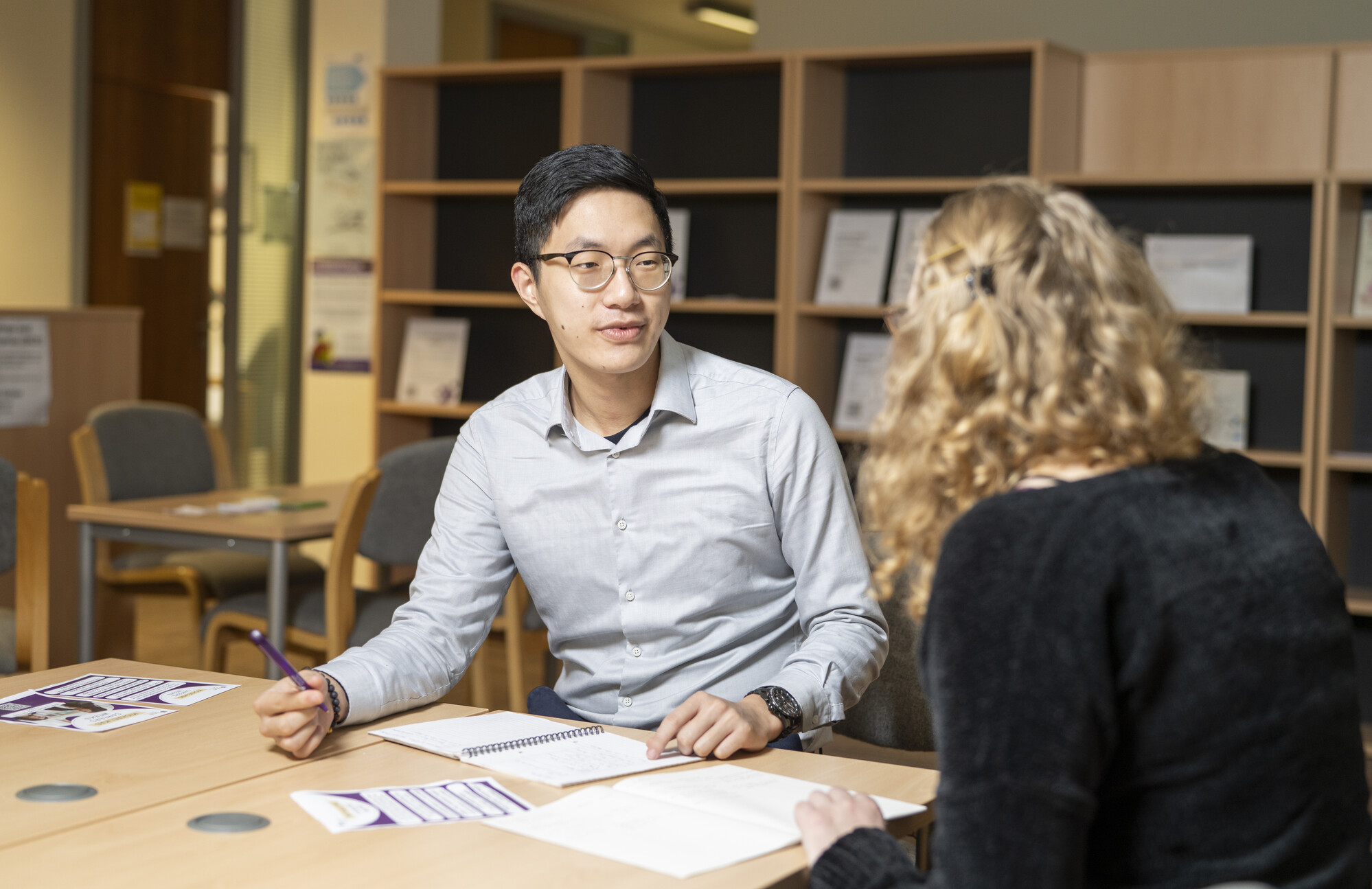 Two colleagues hold a discussion at a table