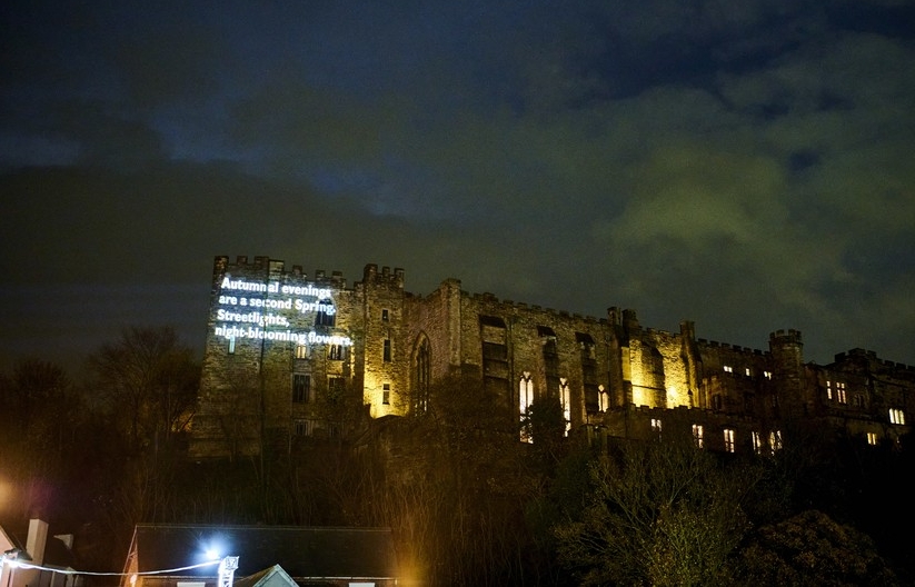 Photograph of a castle with words in white projected onto it. The words read: 'Autumnal evenings are a second spring'
