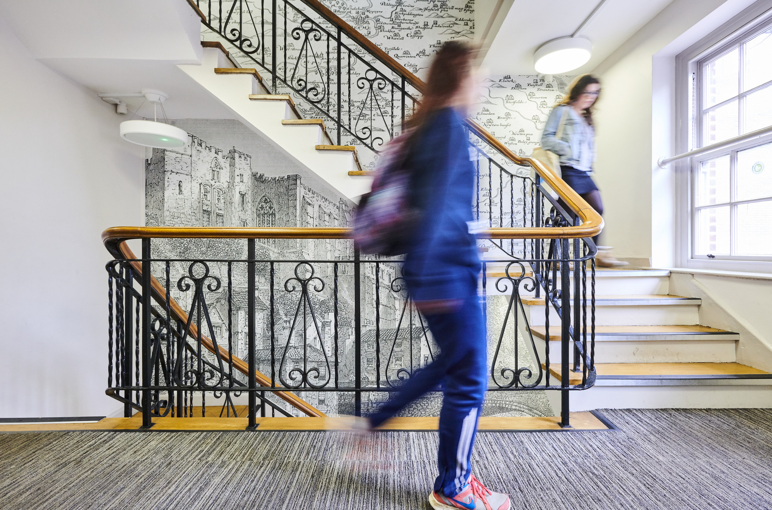 Students walking up a staircase inside the Department of History