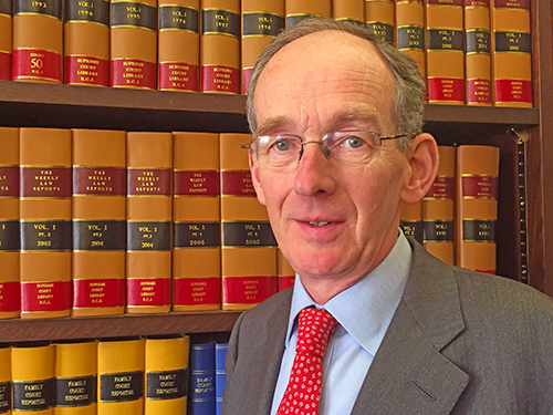 McFarlane in front of a bookcase with Law books