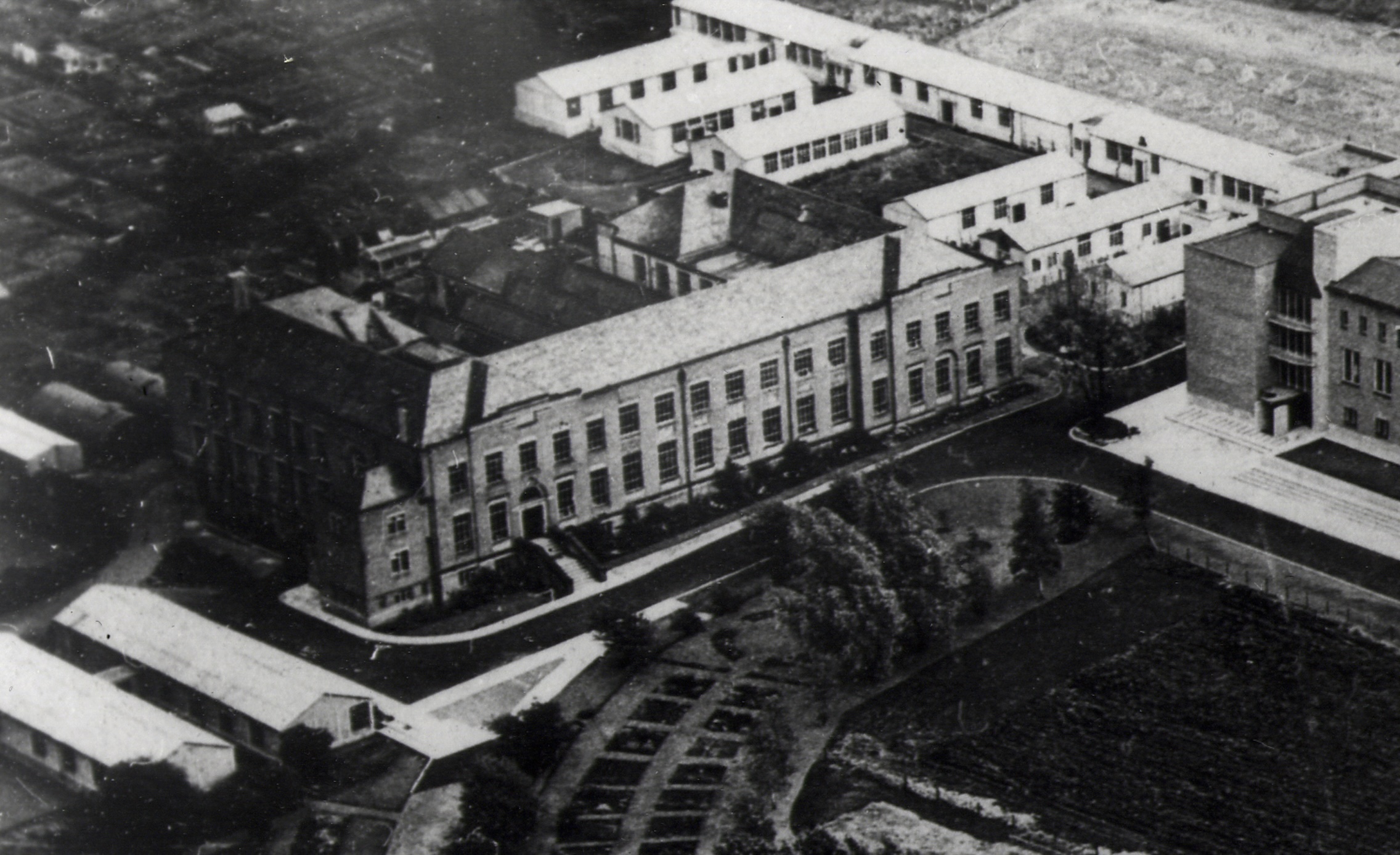 Image of the Dawson Building in the early days, surrounded by huts