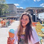 female student smiling and holding a blue ice cream