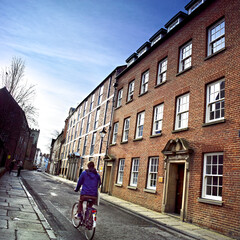 Student cycling past History Department