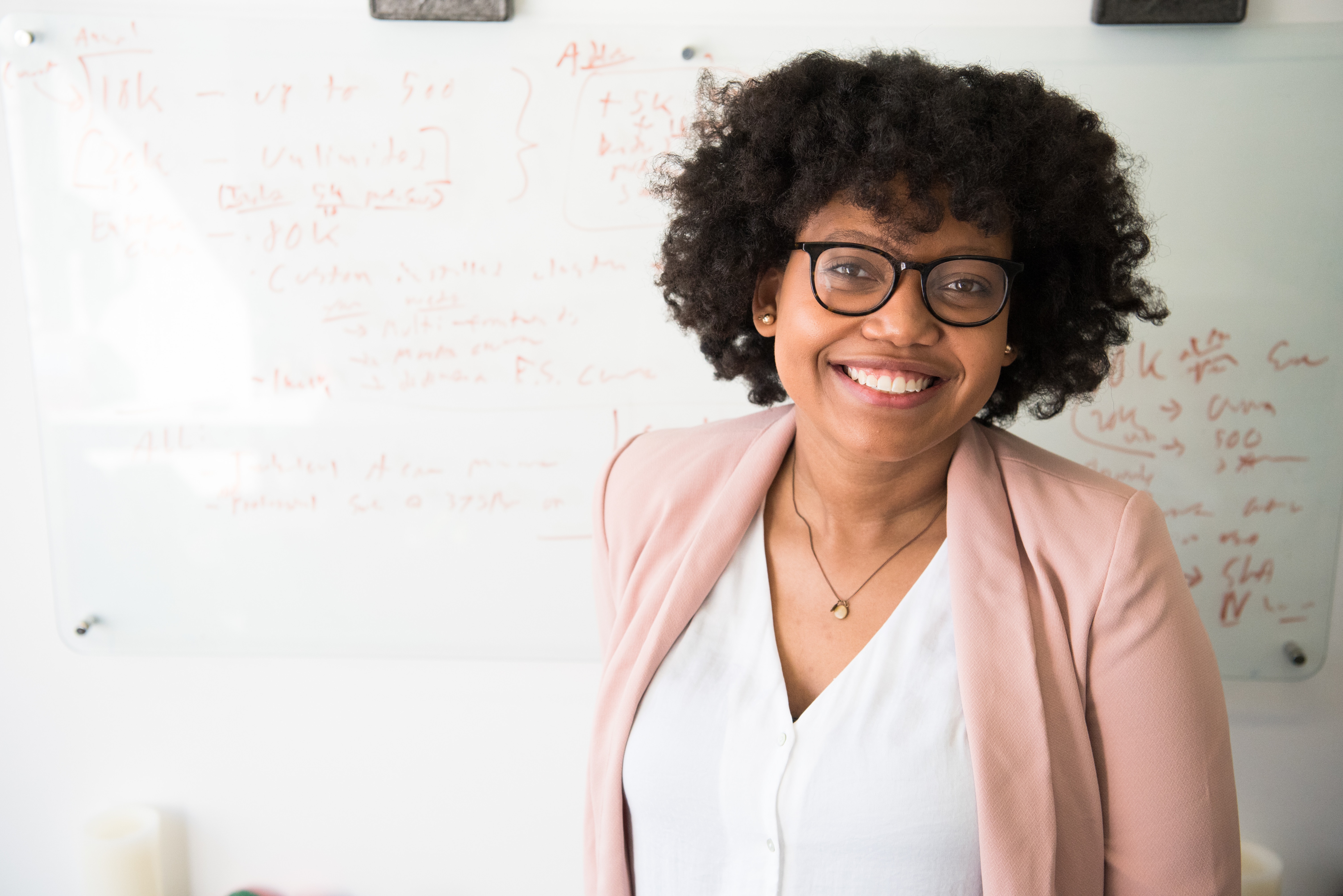 Woman in front of whiteboard smiling