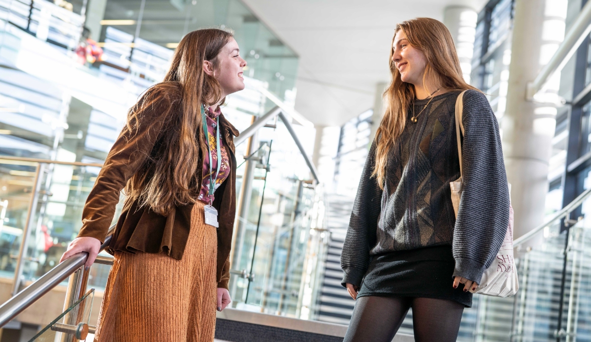 Two people standing on stairs smiling at each other