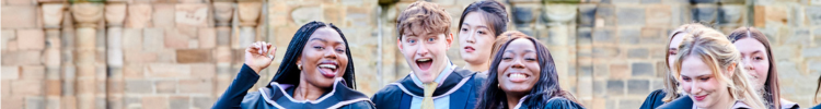 A group of students in gowns outside Durham Cathedral