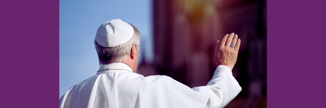 The pope faces away from the camera and raises his right hand