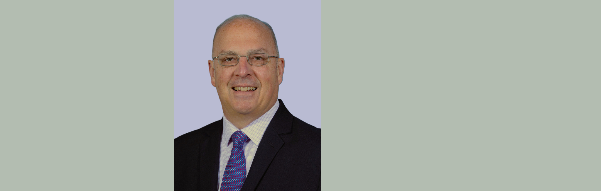 A smiling man in a suit and tie