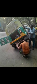 Men fixing a broken auto rickshaw