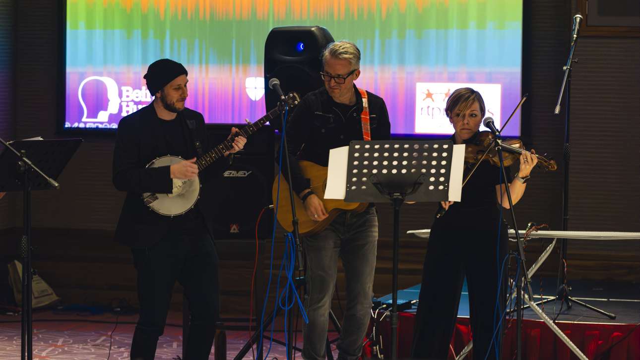 A group of three musicians playing on stage.