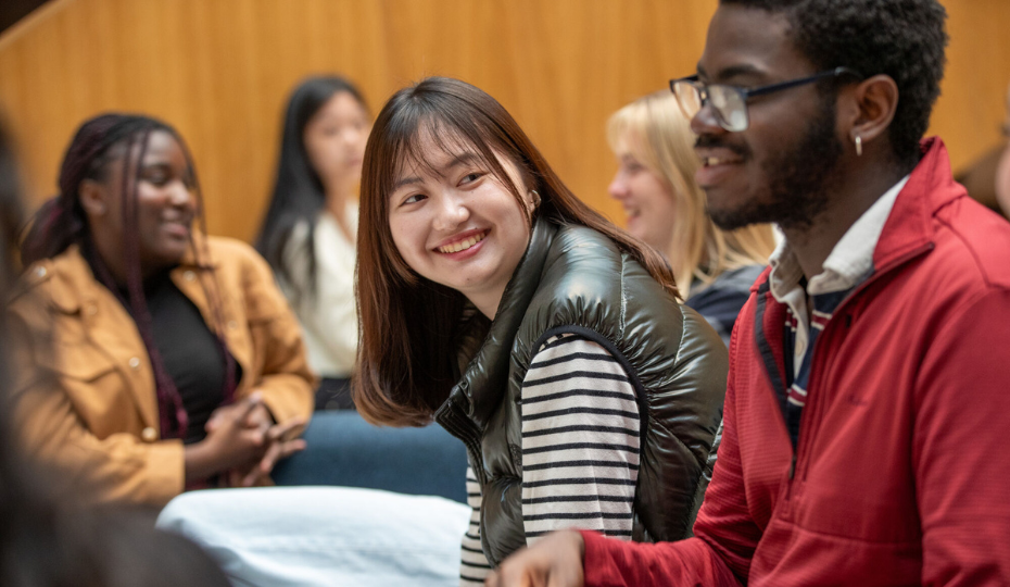 A male and female student sitting next to each other, smiling.