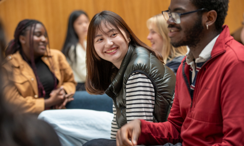 Student looking at another student, with others in the background